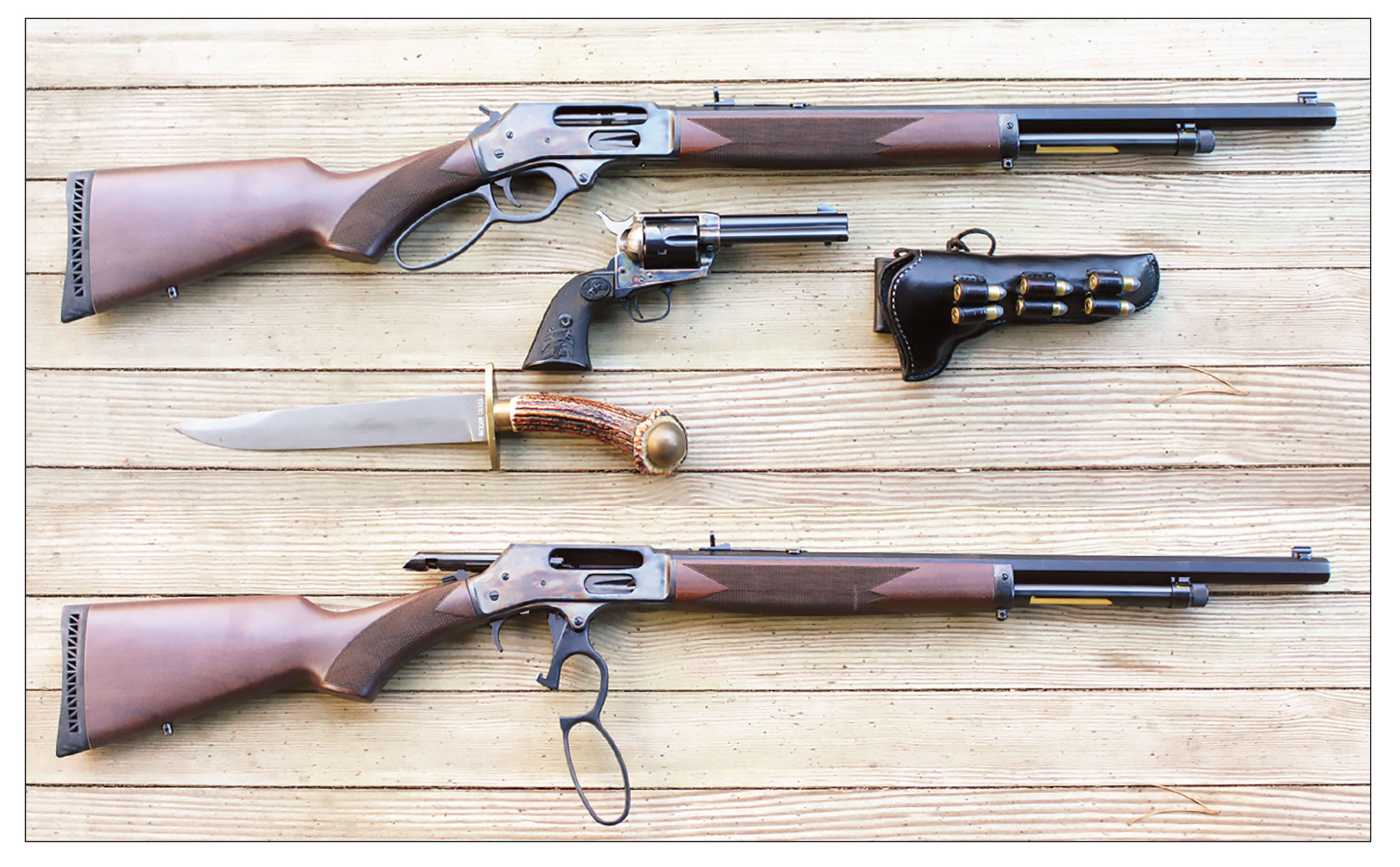 Above, a lever-action 45-70, a Colt .45 SAA and a Bowie knife are as valuable now as they were on the frontier for hunters. Below, the Henry rifle with the action open.